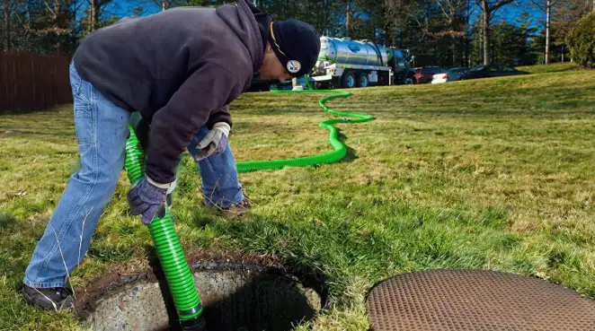 Service technician performing residential septic pumping and drainage maintenance in Worcester, MA